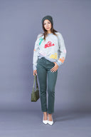 Pantalon straight-leg vert foncé porté avec un pull gris brodé et un bonnet assorti.
