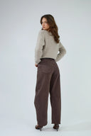 Jean barrel Louisa de couleur marron foncé et pull en maille beige chiné.