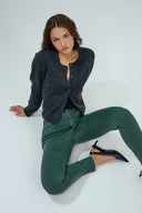 Pantalon slim push-up de couleur vert forêt porté avec un cardigan gris anthracite.