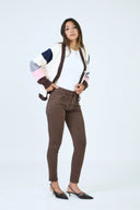 Pantalon slim push-up de couleur marron porté avec un cardigan bicolore et un top blanc.